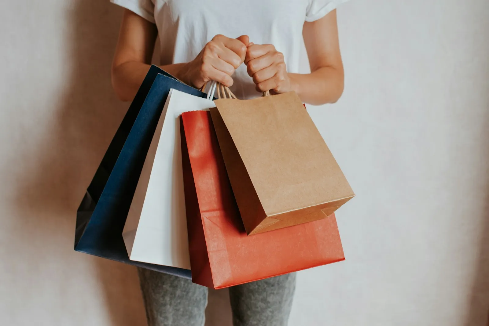 Persona sosteniendo bolsas de compras de colores, temporada de ofertas del Buen Fin en México