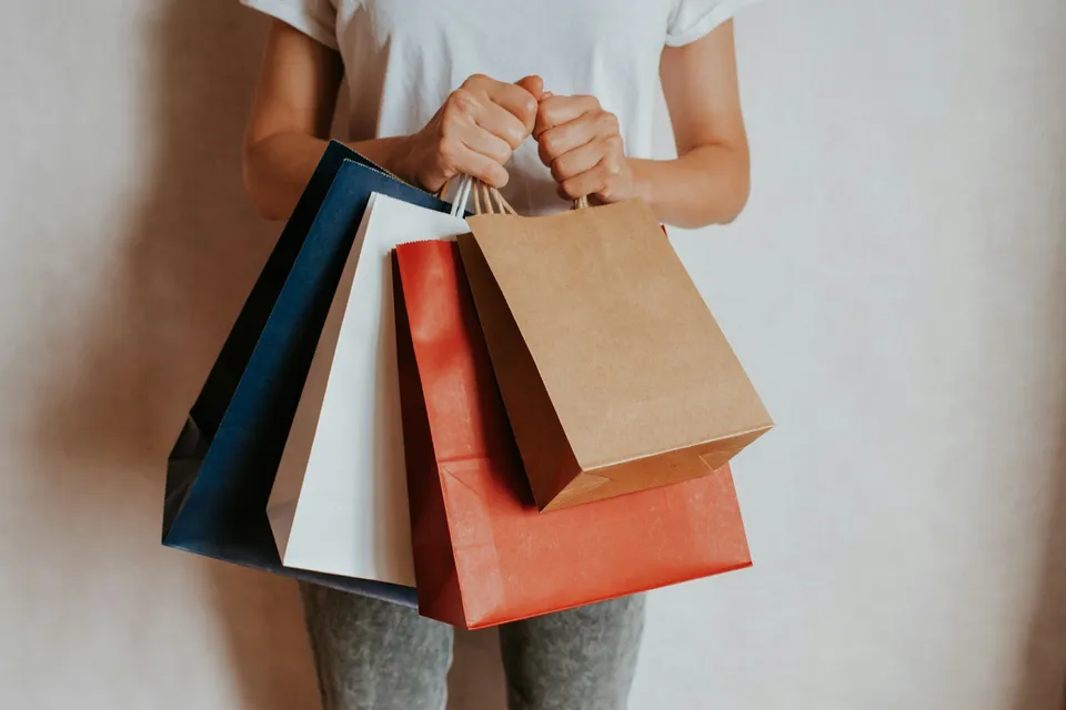 Persona sosteniendo bolsas de compras de colores, temporada de ofertas del Buen Fin en México