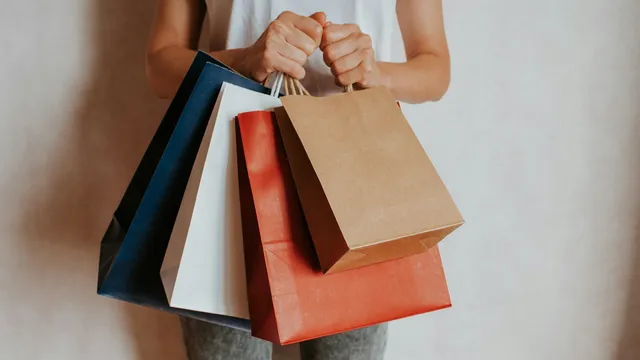 Persona sosteniendo bolsas de compras de colores, temporada de ofertas del Buen Fin en México