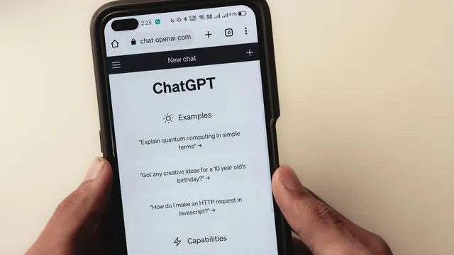 Persona sosteniendo un celular con una conversación de chat abierta, atención automatizada a clientes