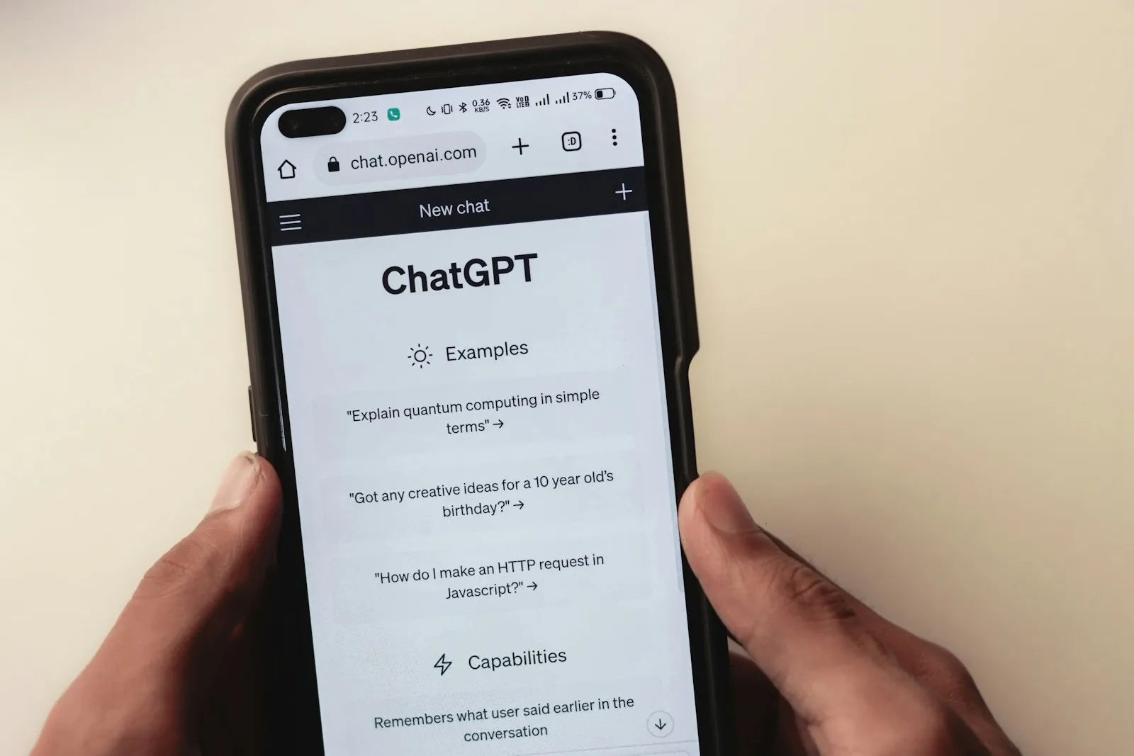 Persona sosteniendo un celular con una conversación de chat abierta, atención automatizada a clientes