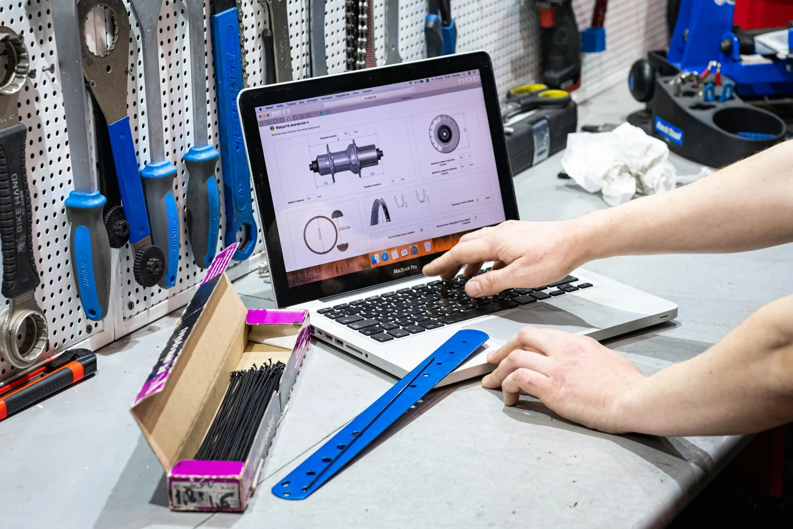 Persona trabajando en una laptop rodeada de herramientas, mantenimiento técnico de un sitio web
