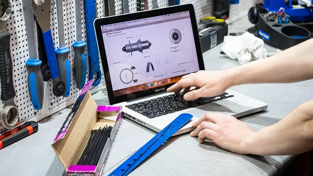 Persona trabajando en una laptop rodeada de herramientas, mantenimiento técnico de un sitio web