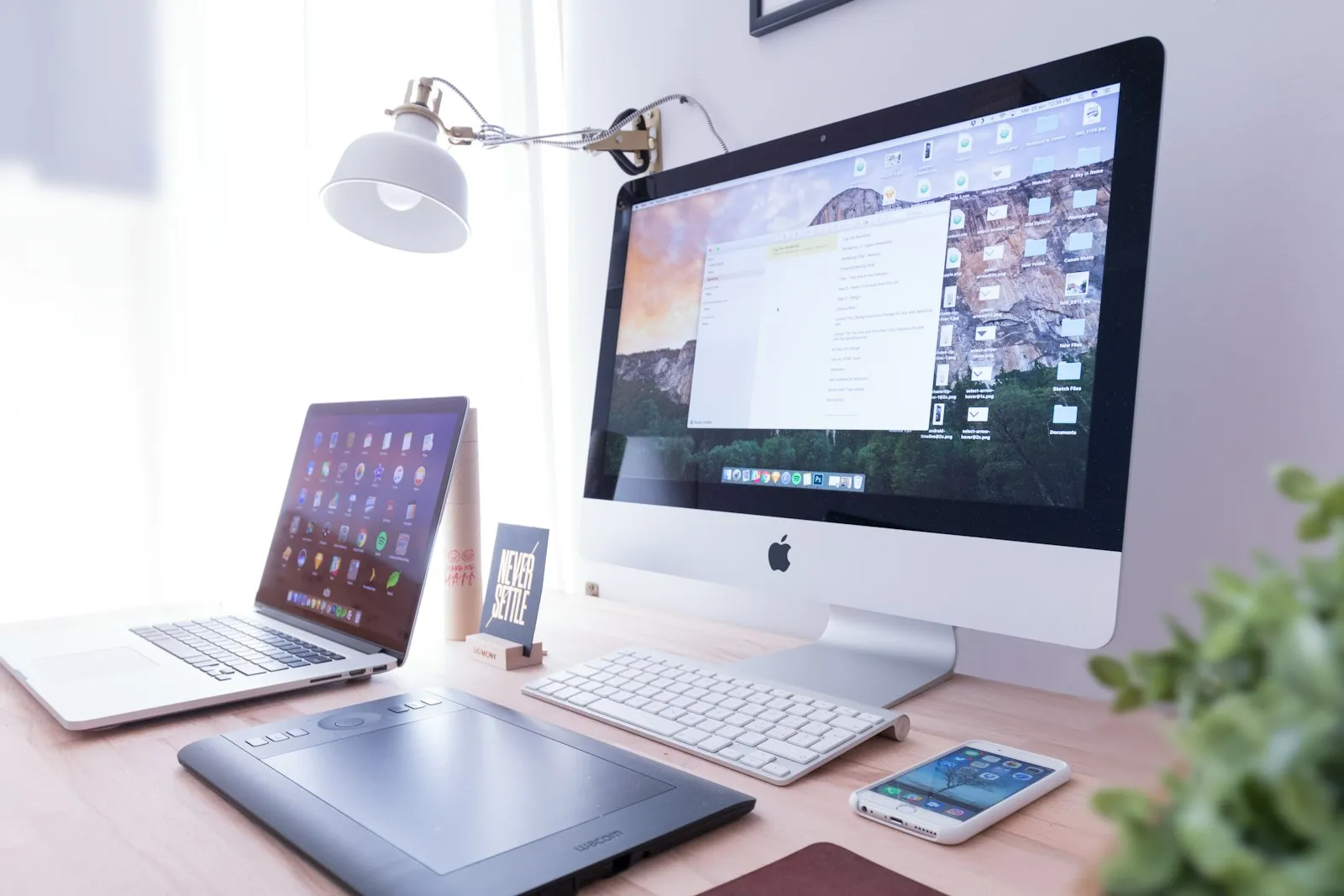 Escritorio minimalista con una iMac mostrando un sitio web, espacio de trabajo de diseño web