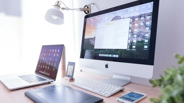 Escritorio minimalista con una iMac mostrando un sitio web, espacio de trabajo de diseño web