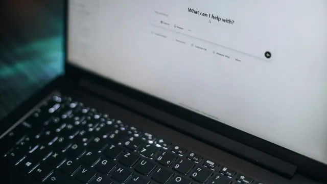 Laptop mostrando un asistente de inteligencia artificial con el mensaje '¿en qué puedo ayudarte?' sobre un escritorio