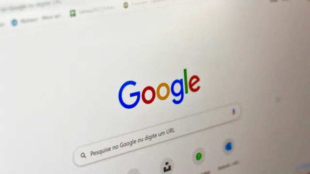 Monitor de computadora mostrando la página de búsqueda de Google, sobre un escritorio de trabajo