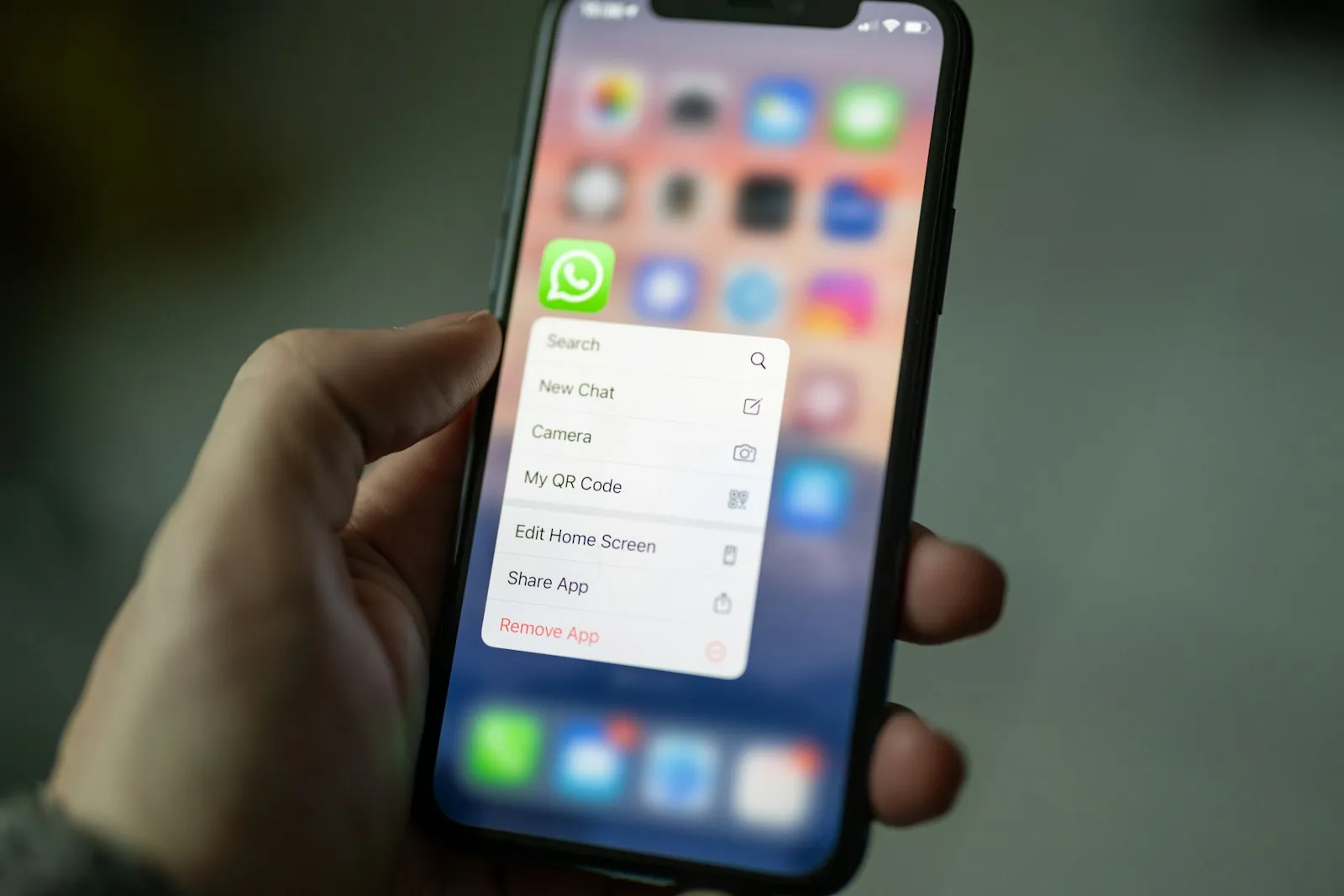 Persona usando un smartphone para atender un pedido, venta por WhatsApp sin tienda en línea